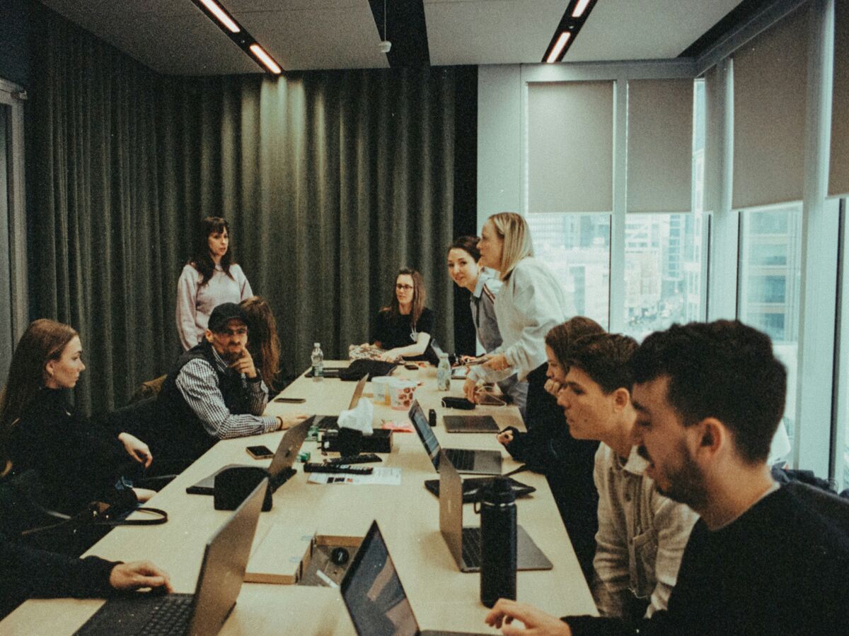 A deal team working on laptops around a long table in a meeting room