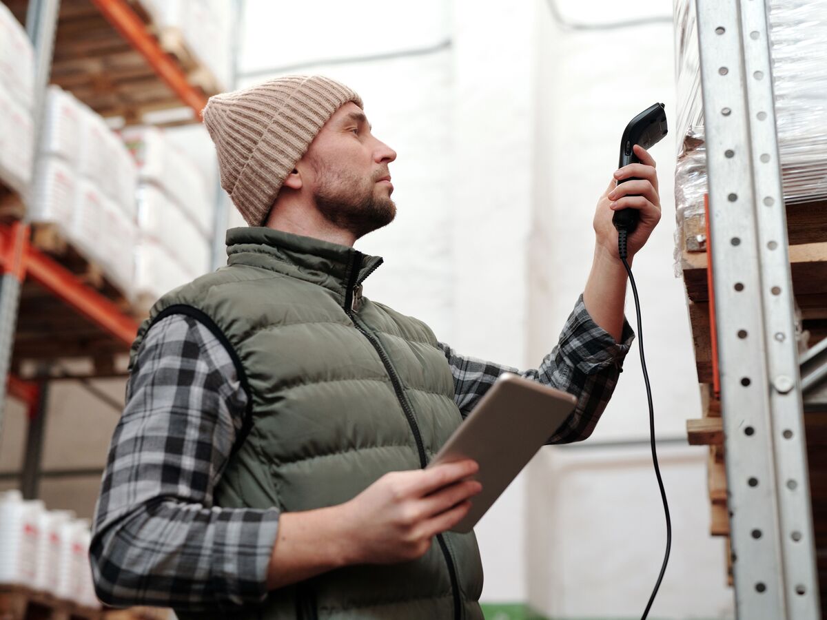 Warehouse worker scanning parcels at a packing station before they ship