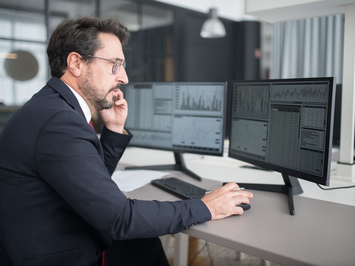 Operations team at a dispatch desk watching dashboards on large wall-mounted screens